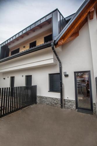 una casa con un balcone con una porta a vetri di APARTMA KATKA Vila Mojca a Kranjska Gora