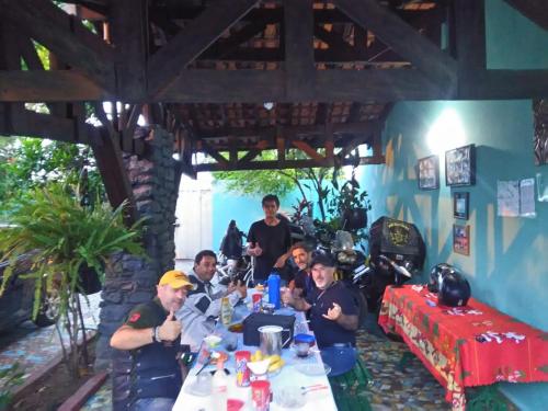 eine Gruppe von Menschen, die an einem Tisch sitzen in der Unterkunft Pousada 4 cantos in Corumbá