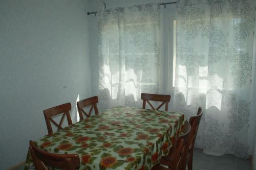 a dining room with a table and chairs and a window at Коттедж в Финляндии, Enonkoski (желтый) in Enonkoski