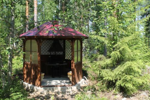 a gazebo in the middle of a forest at Коттедж в Финляндии, Enonkoski (желтый) in Enonkoski