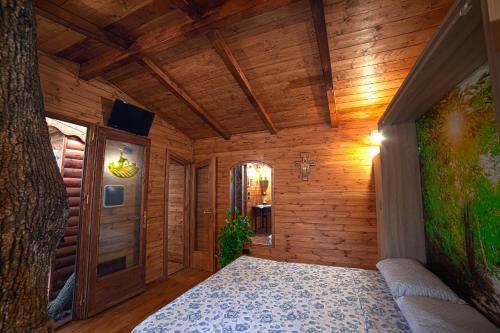a bedroom with wooden walls and a bed in a room at Casa sull'albero Bocchineri in Rogliano