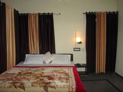 ein Schlafzimmer mit einem Bett mit einer roten Decke in der Unterkunft Om Shanti Guest House in RÄwatbhÄta