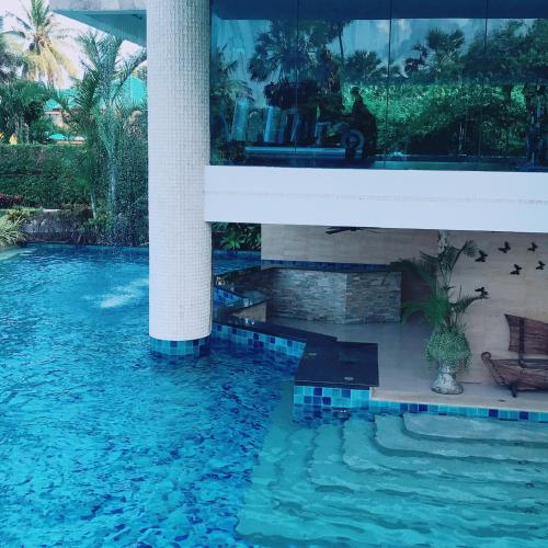 a cat sitting on a bench next to a swimming pool at Luxurious Beachfront Pattaya in North Pattaya