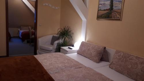 a bedroom with a bed and a chair and a lamp at Hotel Krone Lindow in Lindow
