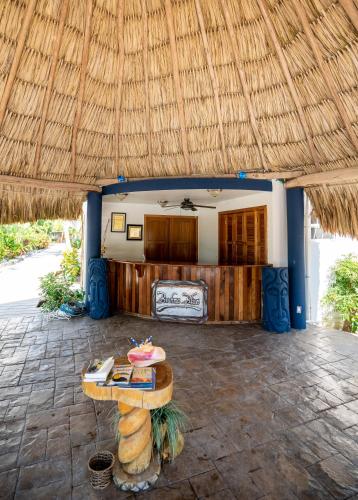 a room with a table and a straw roof at Brahma Blue Resort in San Pedro