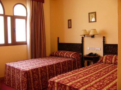 Cette chambre comprend 2 lits et une fenêtre. dans l'établissement Hotel Don Luis, à Madrid