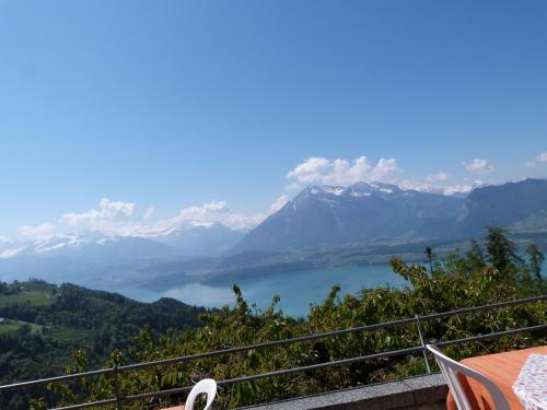 a view of a lake and mountains from a balcony at Hotel Bellevue in Heiligenschwendi