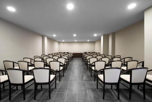 an empty room with rows of chairs in it at Kn Aparthotel Columbus in Playa de las Americas