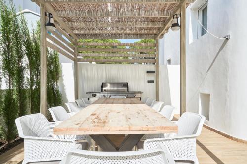 a long wooden table and chairs on a patio at Casa Bianca in Cala Vadella