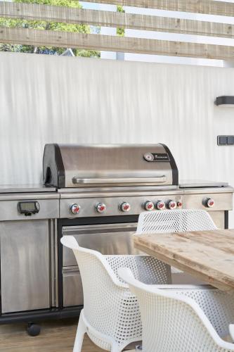 a grill with a wooden table and a table and chairs at Casa Bianca in Cala Vadella