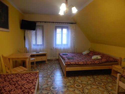 a bedroom with a bed and a desk and window at Penzion Dřevěnka in Osečná