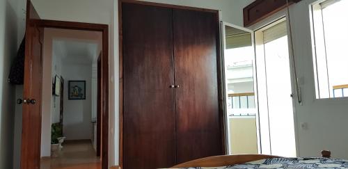 a bedroom with a wooden closet and a bed at Jolie appartement vue mer in M'diq