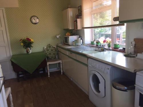 uma cozinha com uma máquina de lavar roupa e um lavatório em 11 Callow Crescent em Minsterley