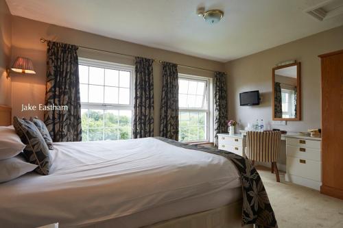 a bedroom with a bed and a dresser and a mirror at Sid Valley Country House Hotel in Sidmouth