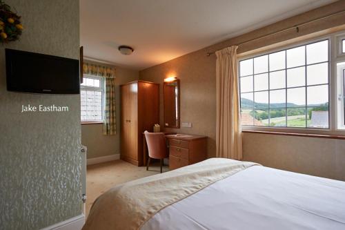 a bedroom with a bed and a large window at Sid Valley Country House Hotel in Sidmouth