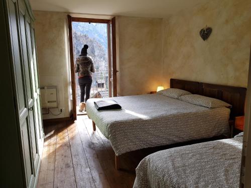 a woman walking into a bedroom with two beds at casa del cirillo in Ornica