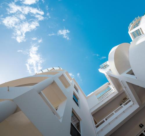 a white building with a blue sky in the background at Brahma Blue Resort in San Pedro