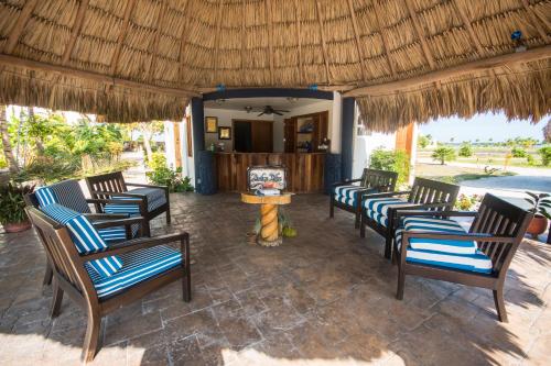 a group of chairs sitting under a straw umbrella at Brahma Blue Resort in San Pedro