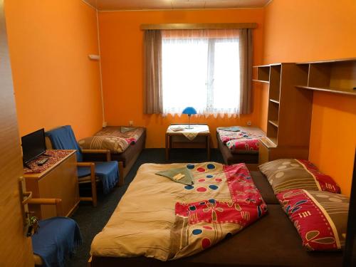 a room with two beds and a desk and a window at Hotel Na Trojce in Wüst-Seibersdorf