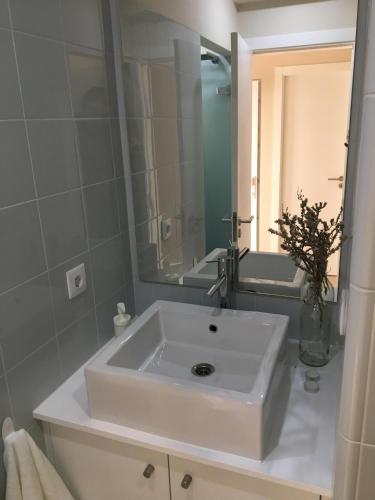 a bathroom with a white sink and a mirror at Casa do Gato que queria ser Pescador in Peniche