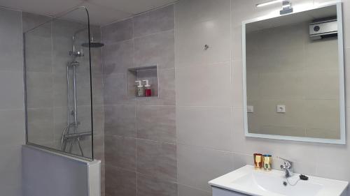 a bathroom with a shower and a sink and a mirror at Manzil Cordoba in Córdoba