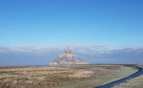 an island in the ocean with a church on top at Domaine Airborne in Angoville-au-Plain