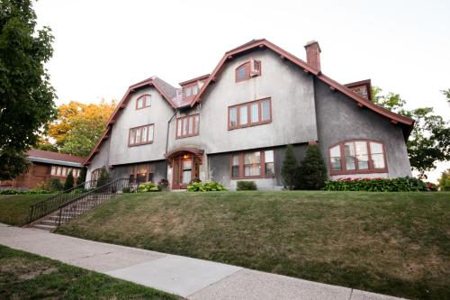 a large gray house with a grass yard at Leonard at Logan House in Grand Rapids