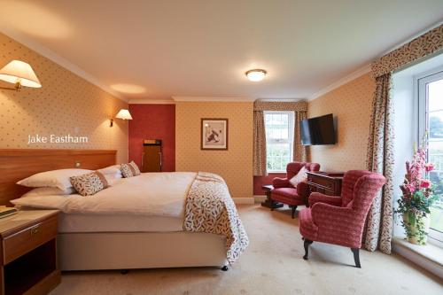 a hotel room with a bed and a chair at Sid Valley Country House Hotel in Sidmouth