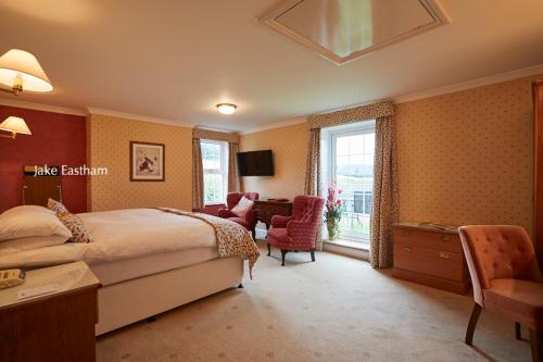 a bedroom with a bed and a desk and chairs at Sid Valley Country House Hotel in Sidmouth