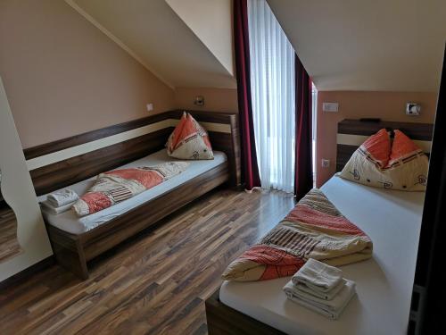 A bed or beds in a room at Borostyán Panzió Balatonfüred