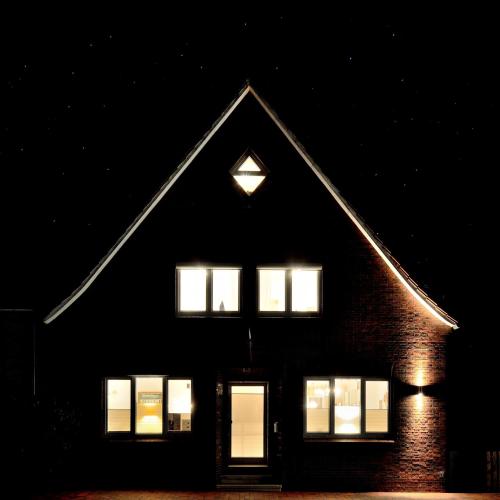 a building with lit windows at night at Vier Sterne am Hafen, Ditzum in Ditzum