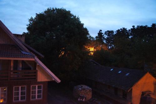 a view of a house at night with trees at Guest House Vasara in Nida