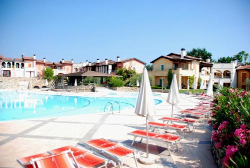 un grupo de sillas y sombrillas junto a una piscina en Sakura House, en Moniga del Garda