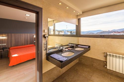 łazienka z 2 umywalkami i dużym oknem w obiekcie Hotel Avenida w mieście La Seu d'Urgell