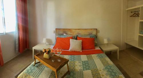 a bedroom with a bed with red pillows and a table at Villa Florencia Bavaro in Punta Cana