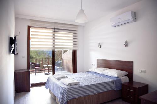 a bedroom with a large bed and a balcony at Şahin Motel & Restaurant in Yaliciftlik