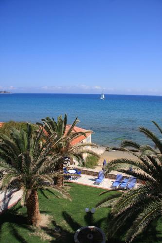 a view of the ocean from a resort with palm trees at Zakantha Beach in Argasi