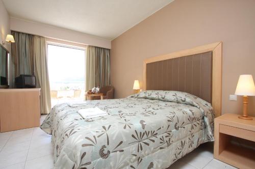 a bedroom with a large bed and a large window at Zakantha Beach in Argasi