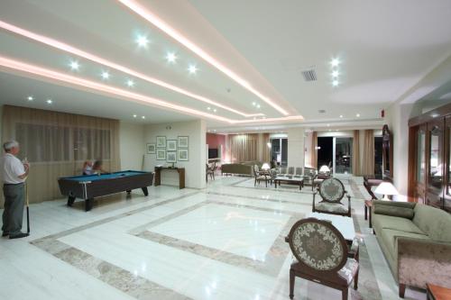 a man standing in a living room with a pool table at Zakantha Beach in Argasi