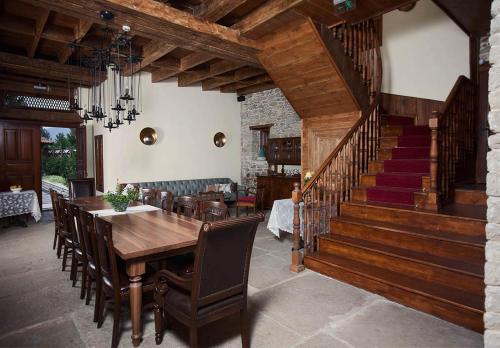 a dining room with a wooden table and a staircase at Pacacioglu Bag Evi in Safranbolu
