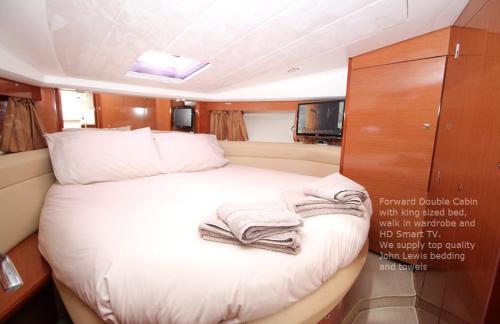a bed in a boat with towels on it at Zen Dog Luxury Motor Yacht in Lymington