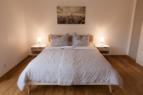 ein Schlafzimmer mit einem großen Bett mit zwei Nachttischen in der Unterkunft Modernes Studio im Herzen von Neustadt: PfalzLiebe in Neustadt an der Weinstraße