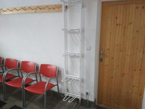 a row of red chairs in a room with a door at Chalupa Krkonoše in Cerny Dul