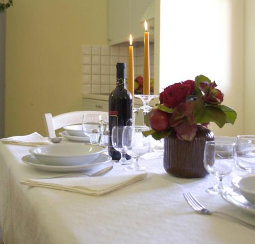 a table with a white table cloth and a bottle of wine at Borgo Degli Ulivi in Àrbatax