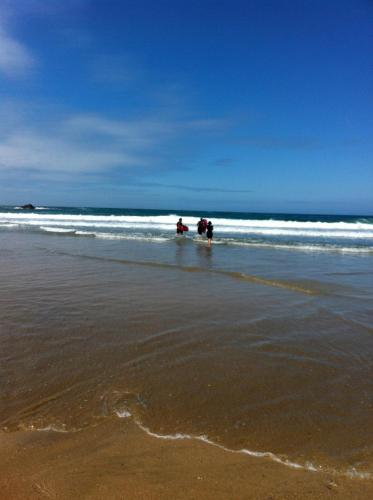two people are standing in the water on the beach at Chy-an-Lowena in Crantock