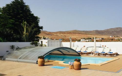 a swimming pool with a canopy over it with chairs at Casa Maida in Tetir