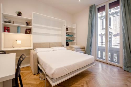 a bedroom with a bed and a desk and a window at Calzolerie Luxury Studio in Bologna