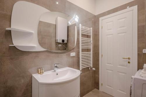 a bathroom with a white sink and a mirror at Calzolerie Luxury Studio in Bologna