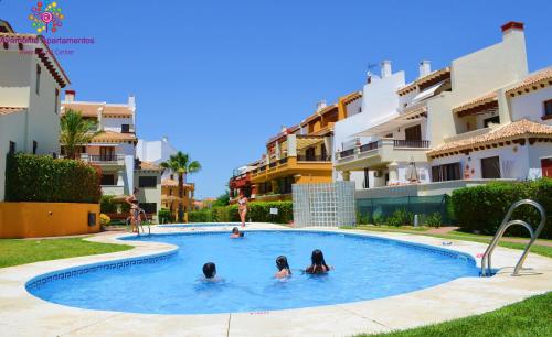 drei Mädchen in einem Schwimmbad in einer Wohnung in der Unterkunft MARINA AZUL GOLF in Ayamonte