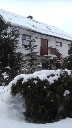 a white house with snow on the roof at ubytování v apartmánu in Mladkov